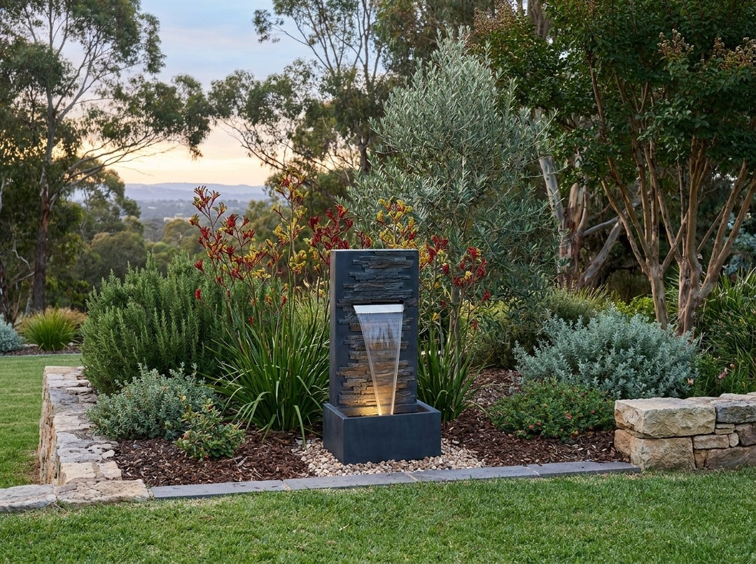 Calm Water Feature in an established Adelaide Hills garden at dusk, water running and its integrated LED lighting glowing