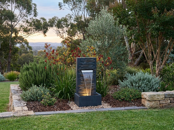 Calm Water Feature in an established Adelaide Hills garden at dusk, water running and its integrated LED lighting glowing