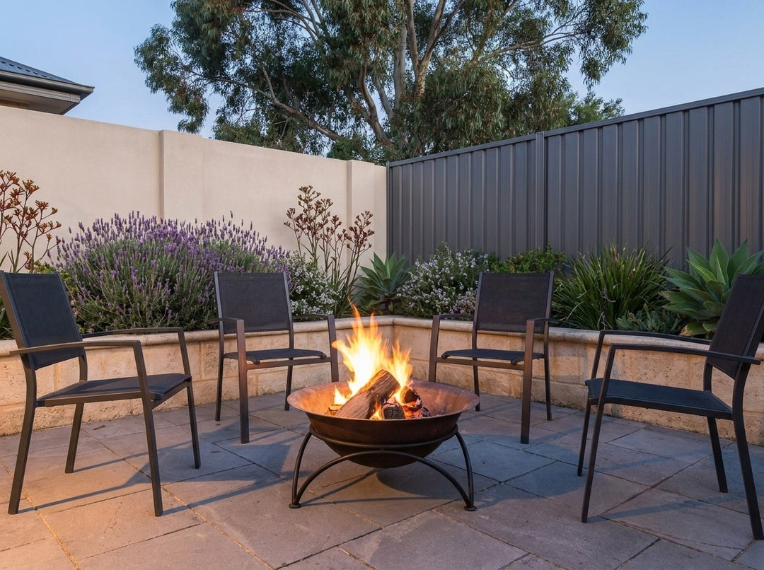 Cast Iron Fire Pit, 60.5 cm across and 30 cm high, burning in a paved Adelaide courtyard at dusk with chairs drawn up around it