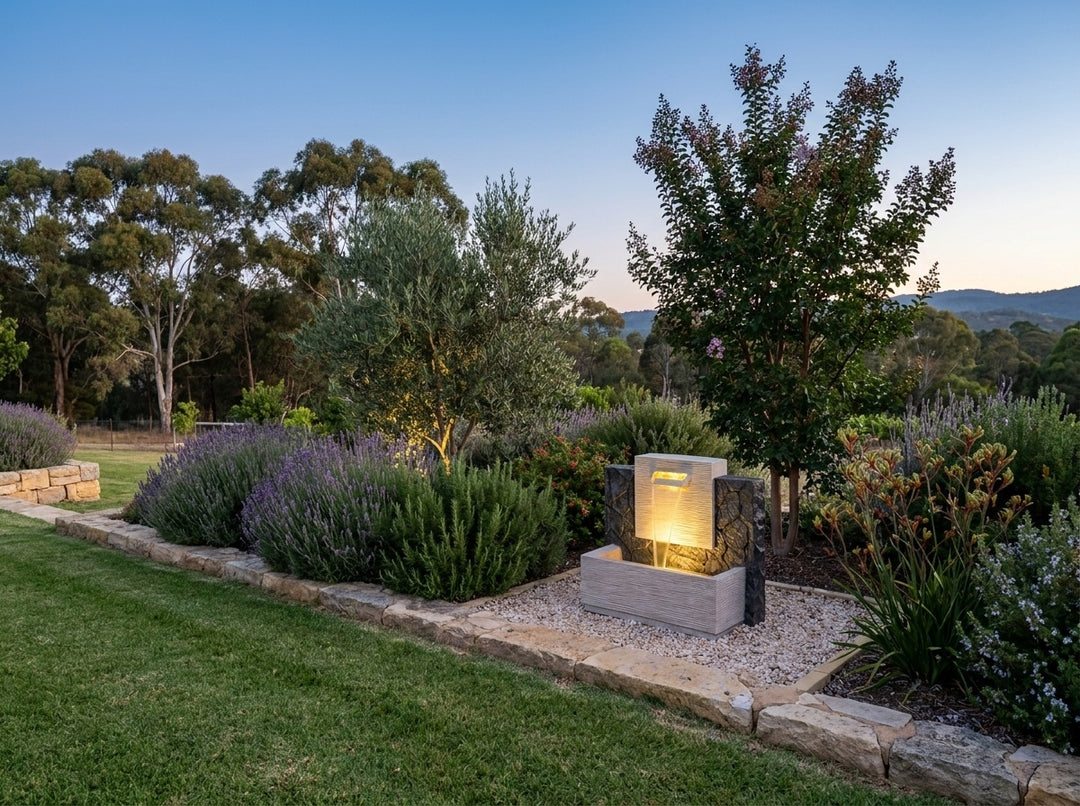 Enchantment Water Feature in an established Adelaide Hills garden at dusk, water running and its integrated LED lighting glowing
