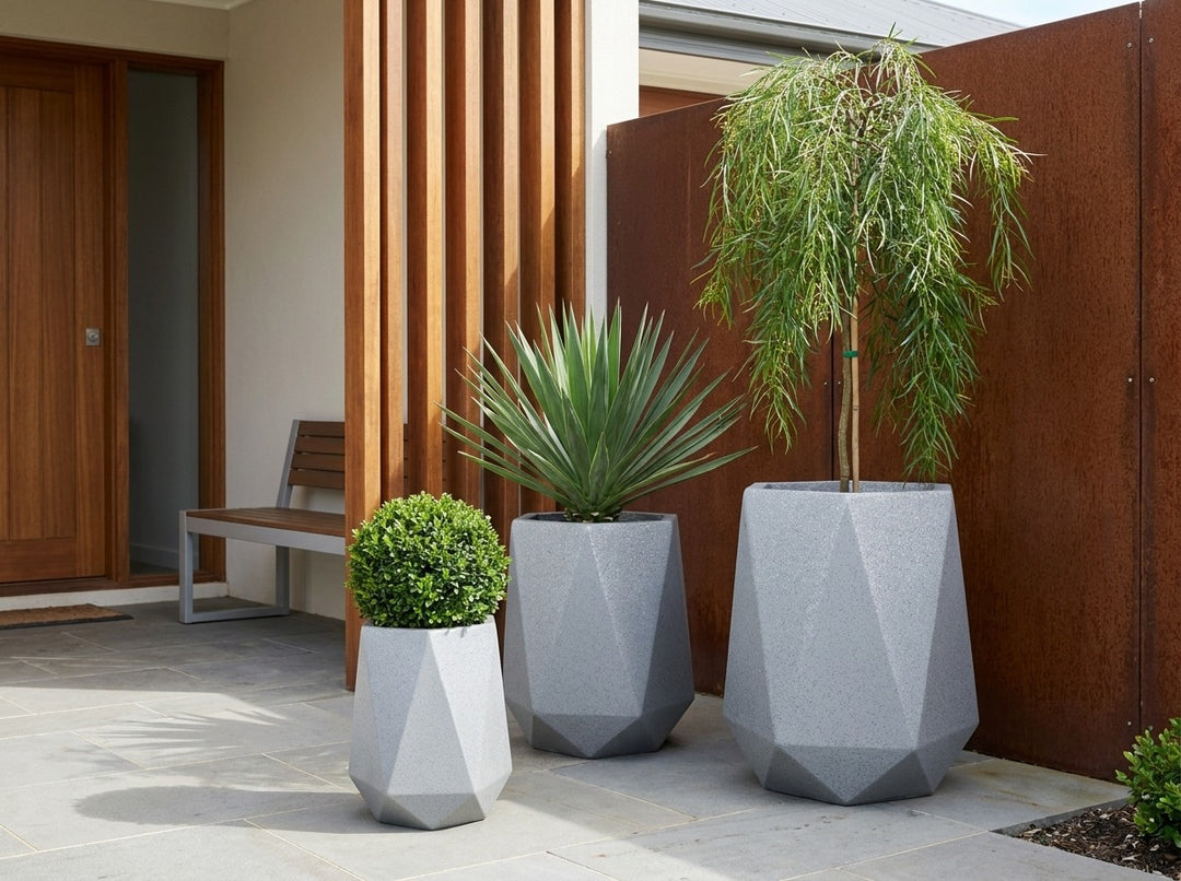 Geo Tall Graphite grey terrazzo faceted planter pots in three sizes at a timber-battened entry