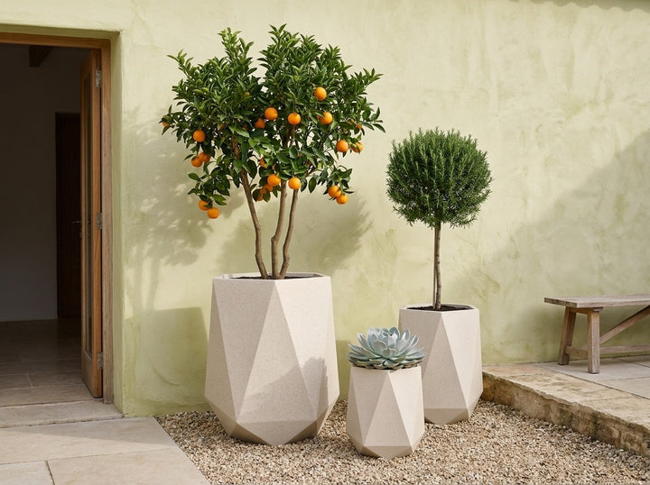 Geo Tall Nougat cream terrazzo faceted planter pots in three sizes in a Mediterranean courtyard