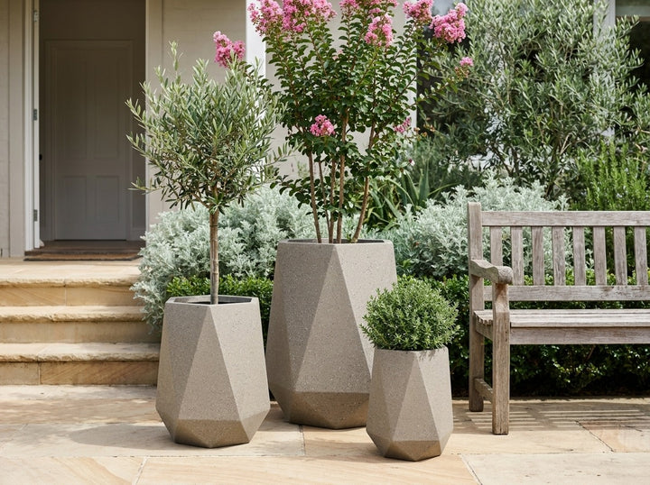 Geo Tall Taupe grey-brown terrazzo faceted planter pots in three sizes on a garden terrace