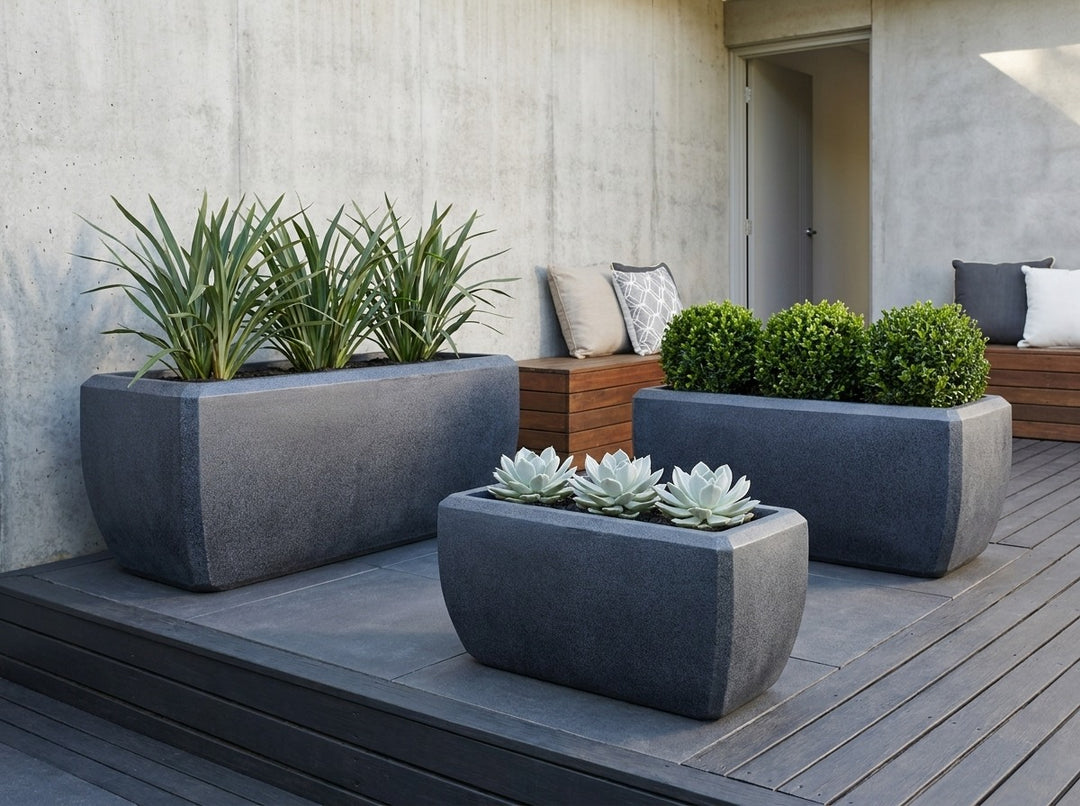 Montego Onyx slate-charcoal terrazzo trough planters in three sizes on a charcoal timber deck