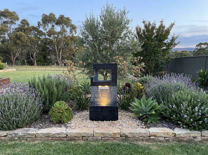 Peace Water Feature in an established Adelaide Hills garden at dusk, water running and its integrated LED lighting glowing