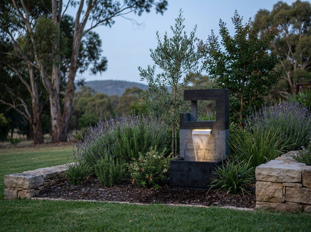 Peace Water Feature in an established Adelaide Hills garden at dusk, water running and its integrated LED lighting glowing