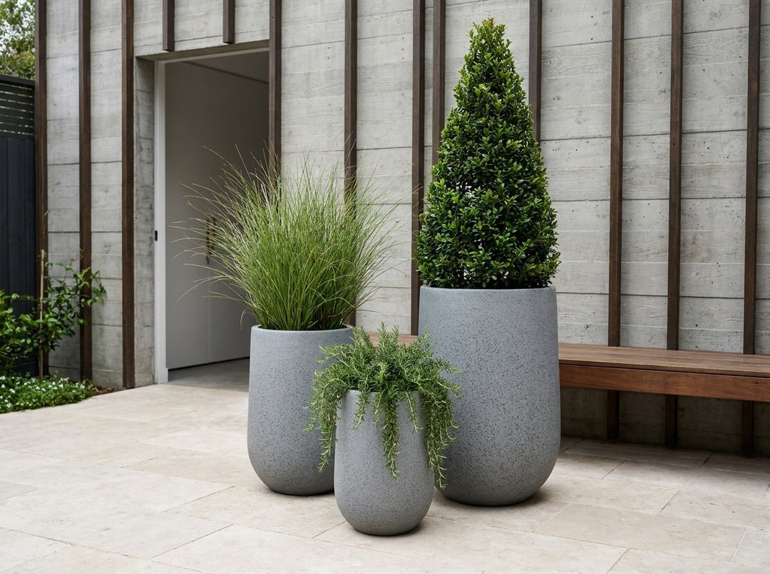 Sorento Granite grey terrazzo U-shaped planter pots, set of three, in a concrete courtyard
