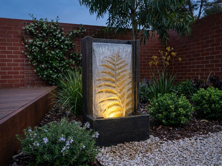 Tranquility Water Feature in a small city townhouse garden at dusk, water running and its integrated LED lighting glowing