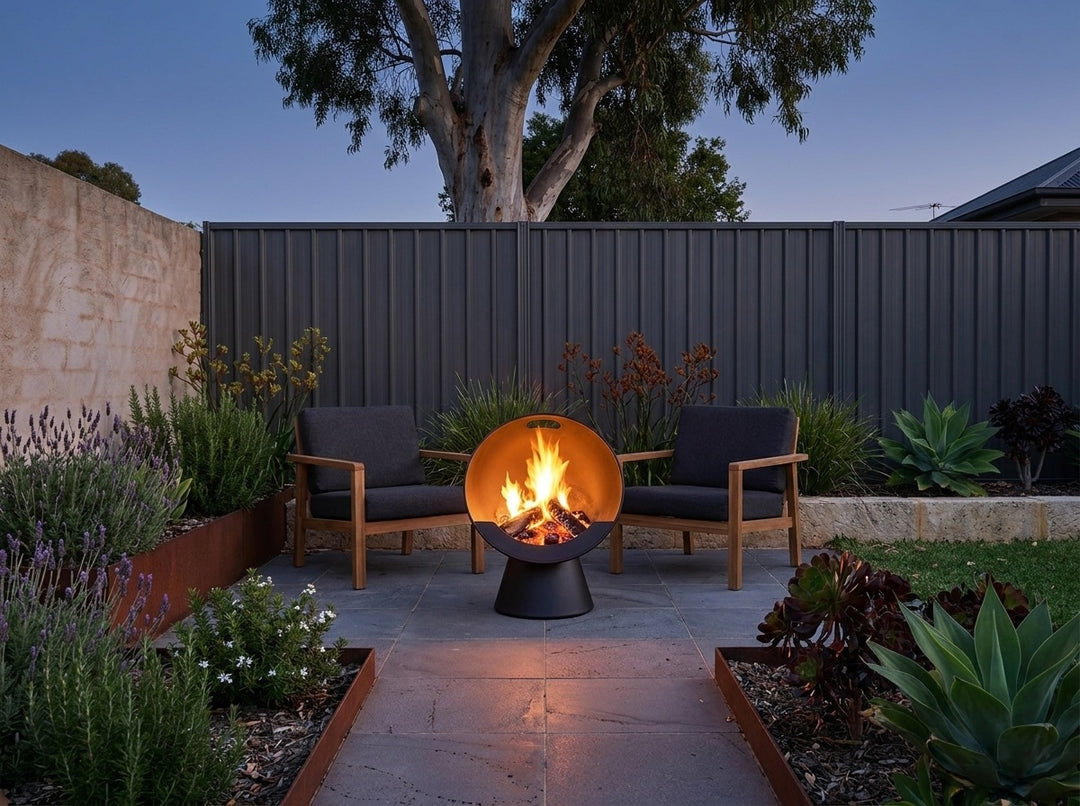 Upright Fire Pit, 61 cm across and 74.5 cm high, burning in a paved Adelaide courtyard at dusk with chairs drawn up around it